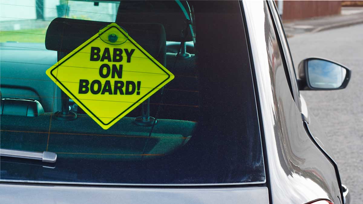 Baby on board sign on car window