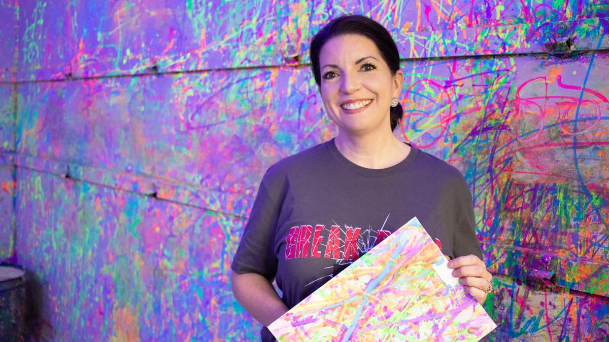 Tiffany Donovan, one of the owners of Break Room 405, in a splatter paint room (Photo: <a href="https://edmondbusiness.com/author/brent-fuchs/">Brent Fuchs</a>)
