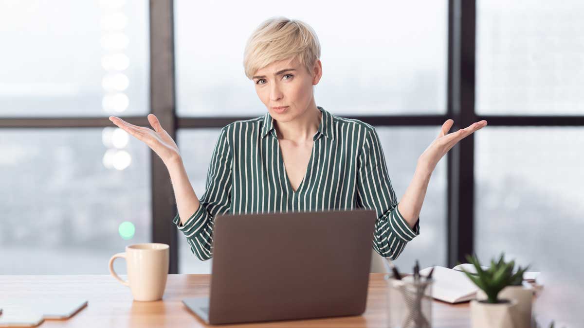 Woman shrugging with laptop