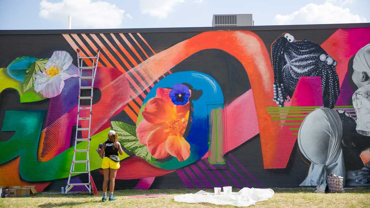 Female artists spray paint new public art in downtown Edmond. (Photo: <a href="https://edmondbusiness.com/author/brent-fuchs/">Brent Fuchs</a>)