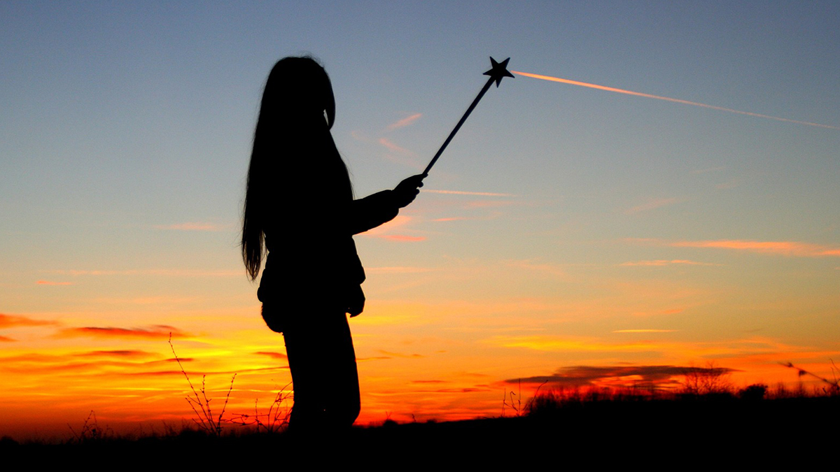 Woman with magic wand at sunset